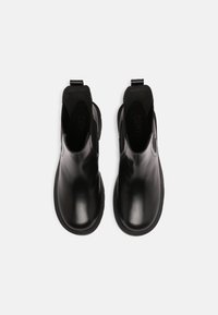 Czarne skórzane botki za kostkę o gładkim wykończeniu, z elastycznymi panelami po bokach i pętelką do ściągania. Posiadają zaokrąglony nosek i płaską gumową podeszwę.