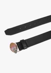 Czarny skórzany pasek z ozdobną klamrą w kształcie muszli, zdobioną wielokolorowymi kamieniami szlachetnymi w odcieniach różu, żółci, zieleni i niebieskiego.