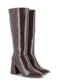 Un par de botas de cuero marrón oscuro hasta la rodilla, con puntas afiladas y tacones cuadrados, sobre un fondo blanco.