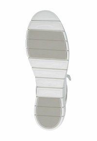 Fehér és világosszürke gumitalpú sportcipő. Vízszintes és függőleges barázdákkal rendelkezik a tapadás érdekében. Lekerekített orrforma, nincs fémalkatrész.