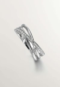 Tres anillos entrelazados de plata pulida, con una fila de pequeños diamantes claros a lo largo de una de las bandas. Diseño suave y elegante.