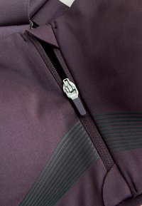 Paarse sportieve zip-up jas met een zilveren rits, textuurstof en donkergroene strepenaccenten aan de voorkant.