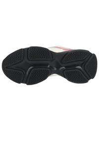 Semelle de chaussure de course en caoutchouc noir texturé, présentant des motifs en zigzag pour l'adhérence et un design de crête centrale lisse.