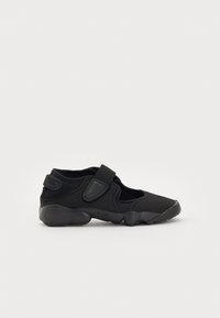 Must have sportlik jalats musta värviga, mis on valmistatud sõmerast pealmisest kihist, velcro rihmaga ja pehme tallaga. Omab ümarat varbaosa ja ventilatsiooniavad, mis tagavad õhuringluse.