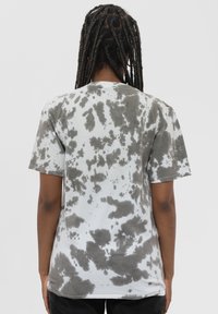 Short-sleeve t-shirt in light gray with dark gray tie-dye pattern. Cotton material, relaxed fit, crew neckline, and straight hem.