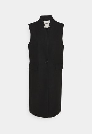 Chaleco negro sin mangas con cuello alto, cierre frontal con botones y dos bolsillos laterales; hecho de tela texturizada.