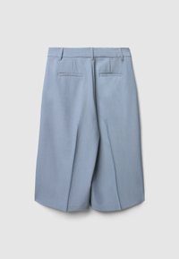 Pantaloni shorts azzurri su misura con una texture morbida, due tasche posteriori e pieghe nette nella parte anteriore. Linee pulite e design strutturato.