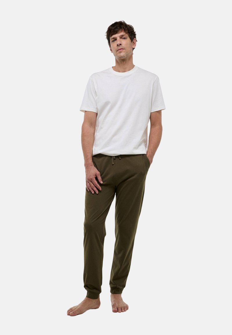 T-shirt à manches courtes blanche et pantalon de survêtement vert olive, fabriqués dans un tissu doux, présentent une taille élastique et des ourlets resserrés.