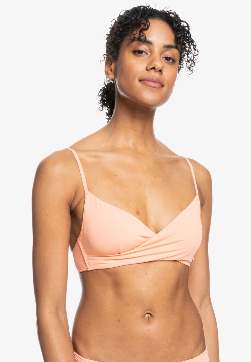 Persiko-färgad bikiniöverdel med svepdesign, tunna justerbara band och en mjuk, elastisk textur. Enkel och minimalistisk stil.
