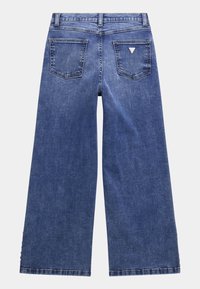 Jeans z szerokimi nogawkami w niebieskim kolorze, z wysokim stanem, wyposażone w dwie tylne kieszenie oraz detal w kształcie trójkąta. Gładka tekstura z klasycznym wykończeniem denimowym.