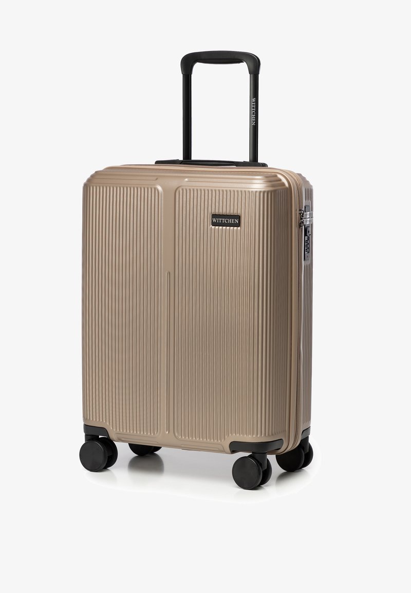 Harde koffer in metallic beige met verticale ribbelstructuur, zwarte wielen en een uitschuifbaar zwart handvat. Merkwaarde aan de voorkant.