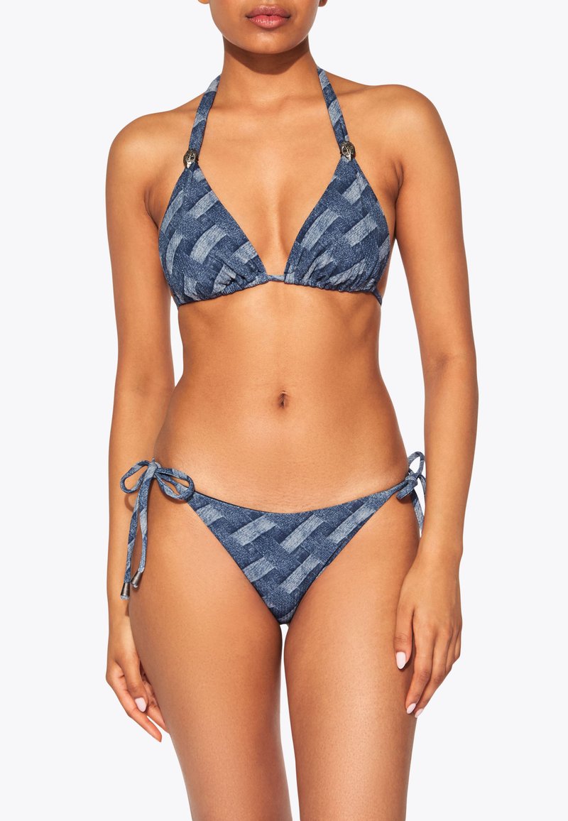 Bikini a motivo denim con top triangolare, spalline a halter e slip con laccetti ai lati. Presenta un design tessuto con una trama in tonalità di blu scuro.