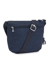 Navy blue crossbody bag made of durable fabric with a textured surface, features a zippered main compartment, adjustable strap, and keychain accent.
