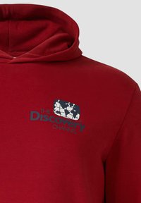 Rote Kapuzenjacke mit einer Fronttasche und einem Logo mit einem Globusdesign in Blau und Weiß. Hergestellt aus weichem, strukturiertem Stoff.