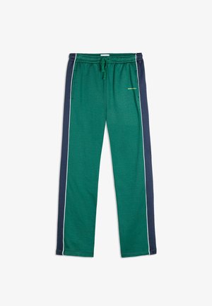 Groene joggerbroeken van zacht materiaal, met marineblauwe zijkanten en witte piping, en een verstelbare tailleband met een trekkoord.