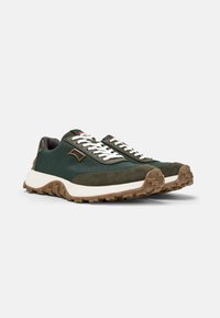 Green suede and fabric sneakers featuring white laces, a rugged sole, and a contrasting brown accent near the heel.