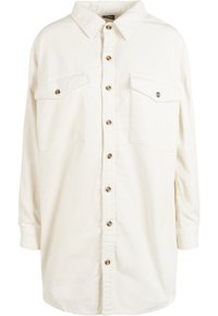 Chemise en velours côtelé blanc avec un col pointu, fermeture à boutons sur le devant et deux poches sur la poitrine. Présente des manches longues et une coupe décontractée.