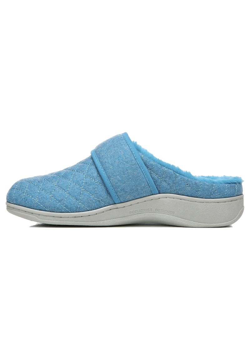 Lichtblauwe, gequiltde stofslippers met een wollige voering, instapontwerp en een gestructureerde grijze zool. Heeft een enkele band over de wreef.