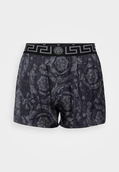 Boxer shorts noirs avec un motif floral ton sur ton, taille élastique avec un design en clé grecque et une fermeture à bouton à l'avant.
