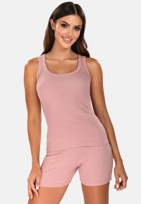 Conjunto de dos piezas de canalé en suave rosa, que incluye una blusa sin mangas con un escote amplio y unos pantalones cortos a juego con un diseño ajustado.