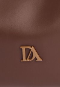 Bolso de cuero marrón con un acabado texturizado y un logo dorado en relieve, "DA," que se muestra de manera prominente en la parte inferior.