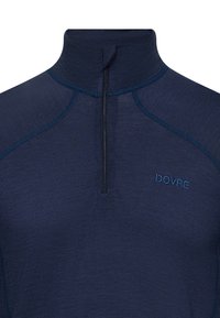 Mørkeblå halvzip trøje lavet af struktureret stof, med høj krave og kontrastsyet detaljer, samt "DOVRE" logo på brystet.