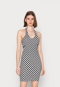 Vestido em padrão de quadrados pretos e brancos, design com pescoço halter, silhueta ajustada, material elástico, textura suave, comprimento até ao joelho.