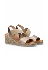 Sandalias de cuña con suela de yute trenzado, que presentan tiras cruzadas metálicas en rosa y beige. Textura suave con un diseño de punta abierta.