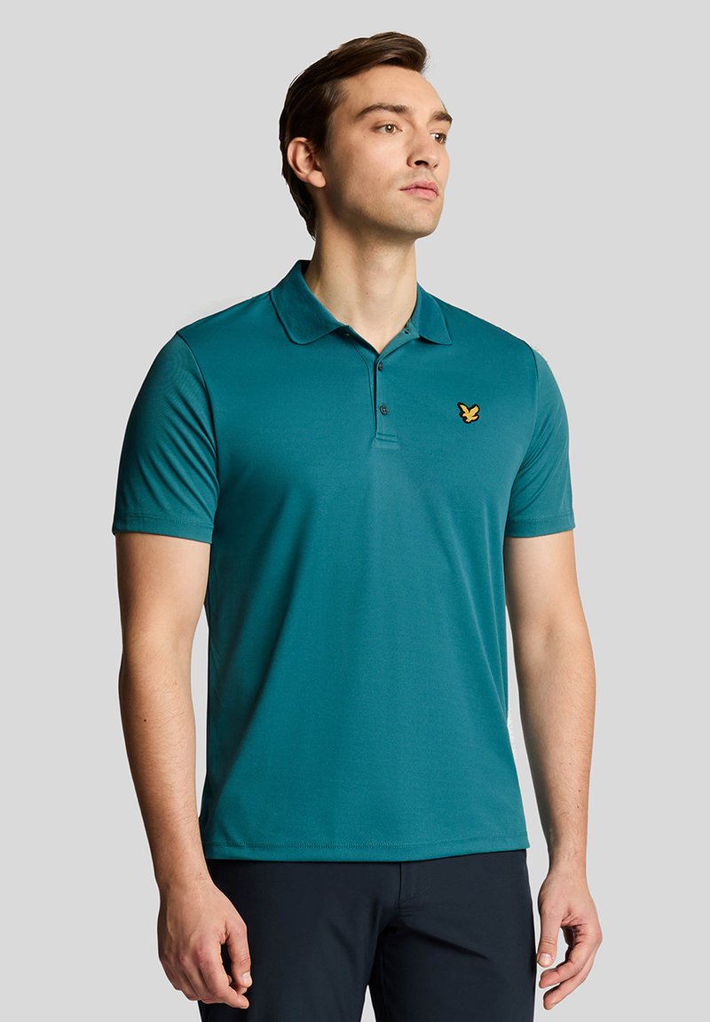 Teal polo shirt made of smooth fabric with a collar, three-button placket, and a gold butterfly logo on the left chest. Short sleeves.