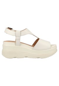 Sandale à plateforme blanche avec semelle épaisse, bout ouvert et bride de cheville ajustable avec fermeture velcro.