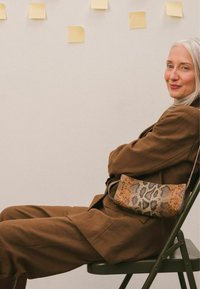 Leren schoudertas met luipaardprint en een bruine basis, met een gladde textuur en slank ontwerp. Minimalistische schouderband en rechthoekige vorm.