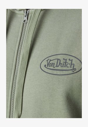 Hoodie zippé vert en tissu texturé avec un logo "Von Dutch" sombre sur le devant.
