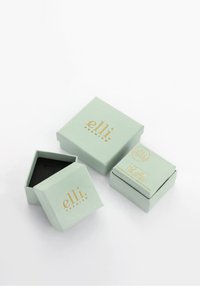Des boîtes carrées vert menthe avec un logo doré, dotées d'un couvercle amovible et d'un compartiment intérieur noir, empilées en arrangement triangulaire.