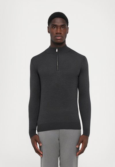 Maglione a coste grigio scuro con colletto alto e zip a un quarto. Le maniche lunghe e i polsini a coste mettono in risalto il design aderente.