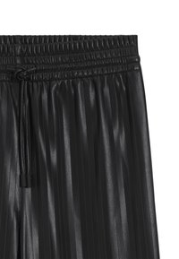 Black pleated pants made of faux leather. Features an elastic waistband with drawstring, showcasing a textured, shiny surface.