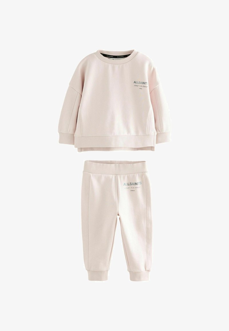 Gaiši rozā bērnu sporta krekls un bikses komplekts ar ALLSAINTS logo un japāņu tekstu, kas drukāts pelēkā krāsā kreisajā krūtī un augšstilbā.