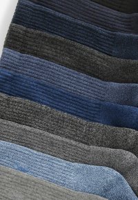Campioni di tessuto in lana in diverse tonalità di blu, grigio e nero, che mostrano una superficie rigata e transizioni di colore distinte.