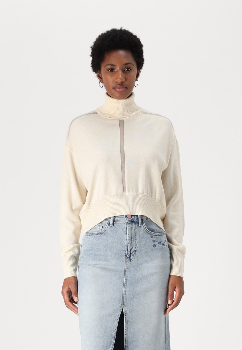 Krēmkrāsas augsta kakla džemperis ar ribotām piedurknēm un apakšmalu. Apvienots ar gaiši zilu denimā ražotu svārku, kam ir priekšējā iegriezuma un ziedu izšuvuma akcenti.