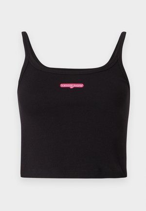 Černý žebrovaný crop top s úzkými ramínky a růžovým logem "tommy jeans" umístěným uprostřed hrudníku. Měkká, elastická tkanina.