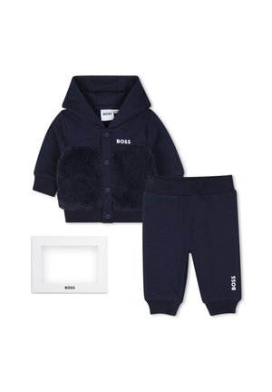 Donkerblauwe babyhoodie met knopen aan de voorkant en zachte panelen, bijpassende broek met elastische taille en een wit rechthoekig BOSS-merkframe.