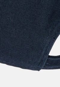 Navy corduroy fabric, featuring vertical ribbing texture, with a curved hem and raw edge detailing. Round cutout at the side for design.