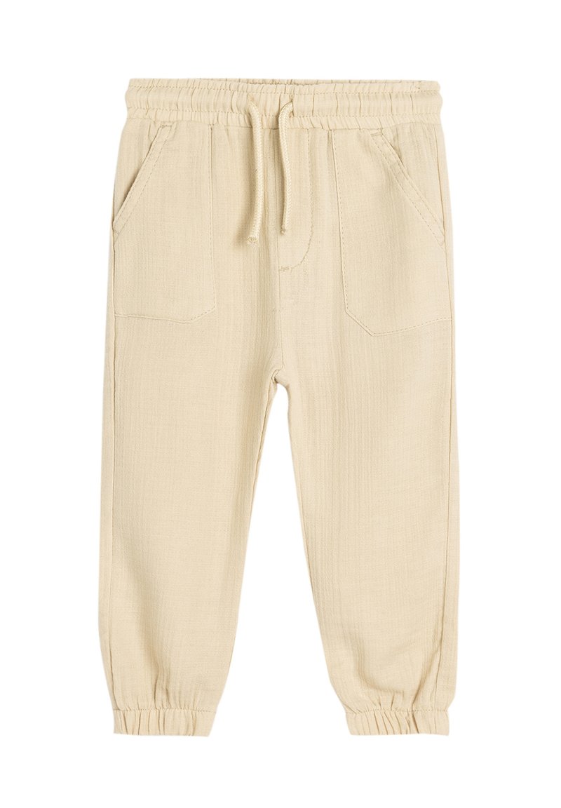 Beige, elastiske bukser med taljebånd, der har to sidelommer, tapered cuffs og en struktureret stofoverflade.
