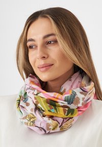 Écharpe florale multicolore en tissu doux et léger. Présente des motifs roses, verts et jaunes sur un fond clair, stylée en boucle.
