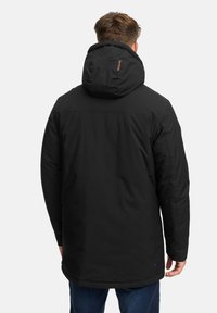 Giacca nera imbottita con cappuccio, caratterizzata da una texture liscia e una silhouette dritta. Include un logo discreto sul collo.