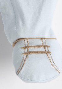 Lichtblauwe stof met crèmekleurige stiksels en geborduurde accenten. Heeft een afgeronde vorm en een gestructureerd oppervlak voor extra detail.