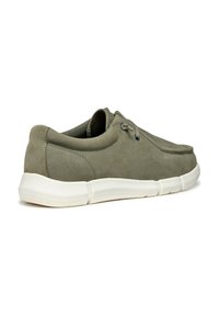 Zapato en ante verde oliva con punta redonda, diseño de cordones y suela de goma blanca. Presenta costuras texturizadas y forro de malla.