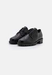 Chaussures noires Oxford avec une finition en imprimé serpent texturé, bout rond et semelle en caoutchouc épaisse. Présente des lacets et un design à talon bas.