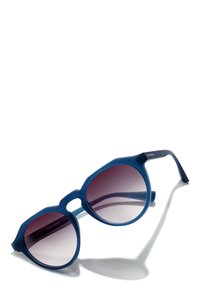 Blaue Kunststoffsunglasses mit einem achteckigen Rahmen, verlaufsfähige Gläser, die von einem dunklen zu einem hellen Lila übergehen, und breiten polierten Bügeln.