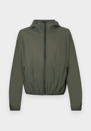 Viegls olīvu zaļas krāsas jaciņa ar kapuci, pilnu rāvējslēdzēja aizdari, elastīgiem aprocēm un savilktu vidukli. Aprīkota ar sānu rāvējslēdzēja kabatām.