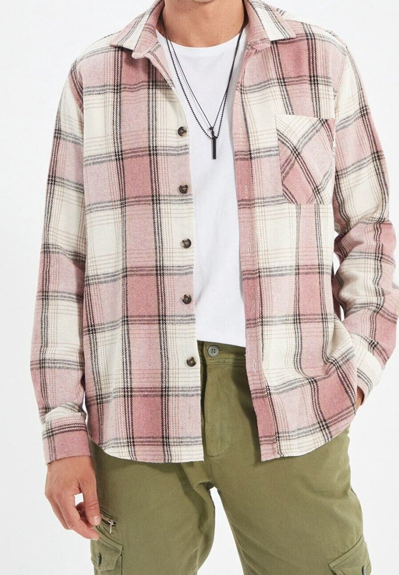 Geruit overhemd van zachte stof met roze, wit en zwart. Gevoerd met knopen aan de voorkant, lange mouwen en een enkele borstzak.